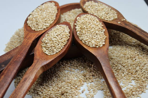 bio natürliche til gul oder sesam samen über weißen hintergrund - sesame stock-fotos und bilder