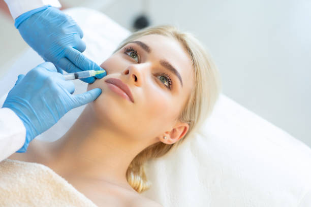 istock Young woman at plastic surgery with syringe in her face 1272204231