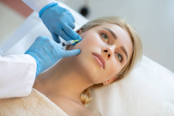 Young woman at plastic surgery with syringe in her face Young woman at plastic surgery with syringe in her face blood plasma photos stock pictures, royalty-free photos & images