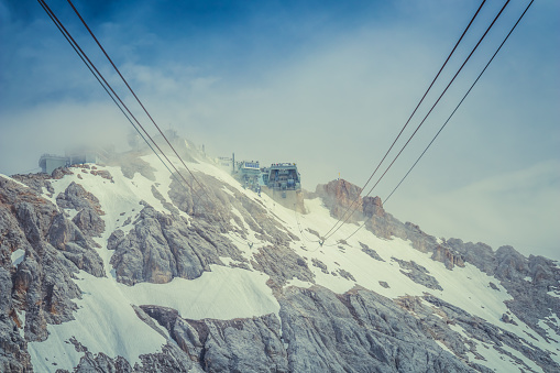 The building complex on the top of Zugspitze mountain and cables of the cable car Gletcherbahn on a sunny summer day.