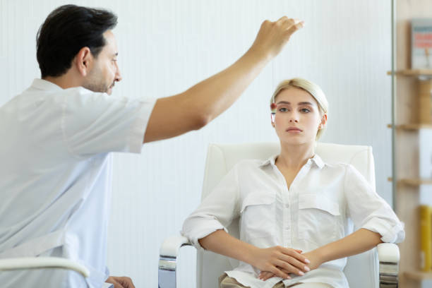 male therapist using hypnosis therapy on young woman - hypnotist therapy alternative therapy alternative medicine imagens e fotografias de stock