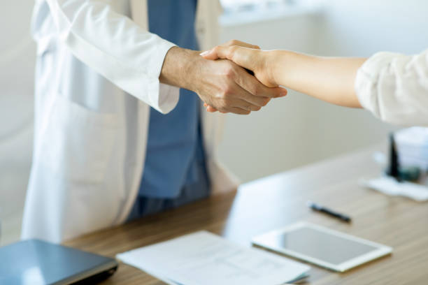 istock Doctor shaking hands with a patient in consulting room 1272205285