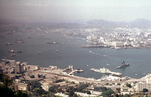 British Hong Kong, China - 1983: A vintage 1980's Fujifilm negative film scan of a collection of docked Chinese shipping cargo container ships in the bay of Hong Kong.