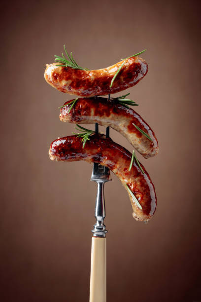 istock Hot sausages on a fork sprinkled with rosemary. 1272206010