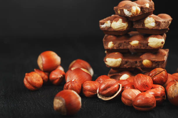 istock Chocolate with hazelnut on a black background close-up. 1272207173
