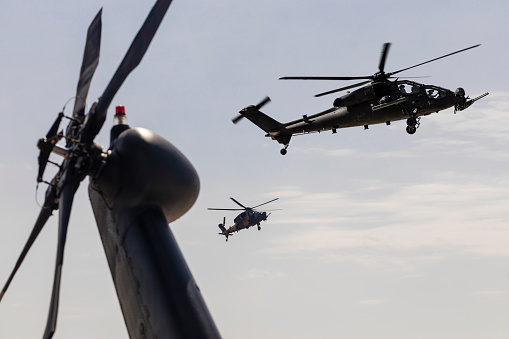 Den Helder, Netherlands – June 30, 2023: A military helicopter and two boats in a lake