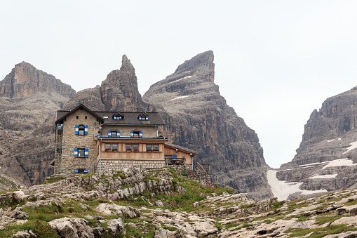 Trentino, Italy - August 23, 2019: Alpine hut Rifugio Tuckett Mountain Cima Sella panorama in Brenta Dolomites. The alpine hut is open from June to September and offers accommodation for 110 people.