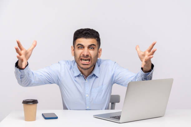 istock Irritated man boss sitting office workplace, stretching hands to camera, looking furious while shouting with anger 1272208866
