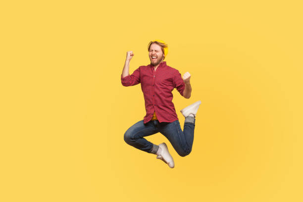 istock Enthusiastic delighted victorious guy jumping high trampoline, flying in air shouting for joy, crazy about success 1272208875