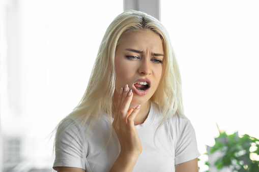 Mujer infeliz que sufre de dolor de dientes photo