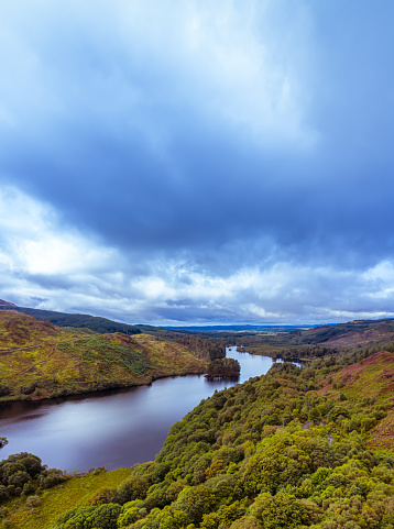 The high angle view of a loch in a remote rural area of Dumfries and Galloway, south west Scotland. Although it is summer the sky is overcast with grey clouds after a shower of rain. The panorama was created by merging several images together.