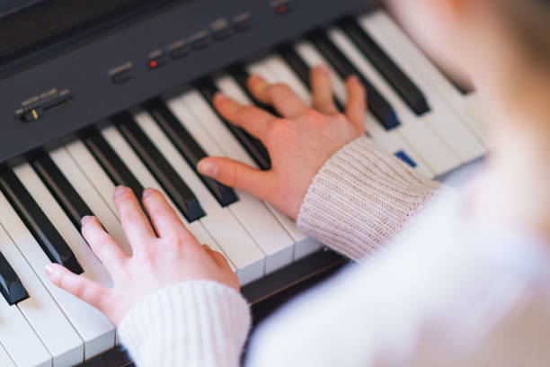 japanische mädchen spielen klavier zu hause - elektrisches piano stock-fotos und bilder