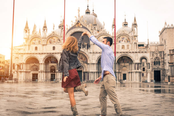 paar reist in venedig, italien - happy men rain water dance stock-fotos und bilder
