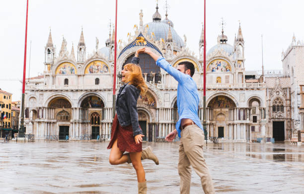 paar reist in venedig, italien - happy men rain water dance stock-fotos und bilder