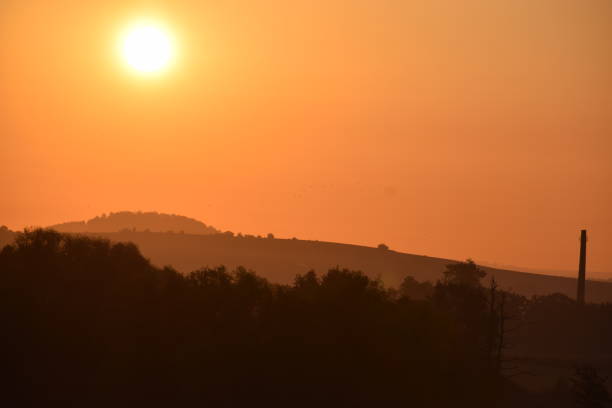 istock orange sunrise sky with the sun over an old volcano hill 1272212578
