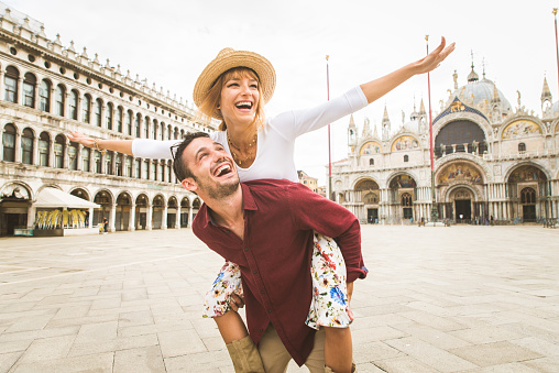 Beatiful young couple having fun while visiting Venice - Tourists travelling in Italy and sightseeing the most relevant landmarks of Venezia - Concepts about lifestyle, travel, tourism