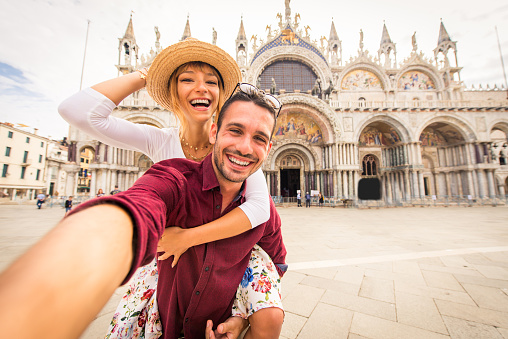 Beatiful young couple having fun while visiting Venice - Tourists travelling in Italy and sightseeing the most relevant landmarks of Venezia - Concepts about lifestyle, travel, tourism