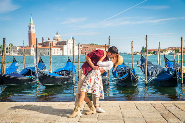 Beatiful young couple having fun while visiting Venice - Tourists travelling in Italy and sightseeing the most relevant landmarks of Venezia - Concepts about lifestyle, travel, tourism
