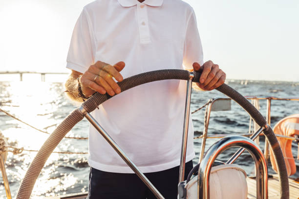 istock Unrecognizable man standing on a yacht and holding a steering wheel 1272217126