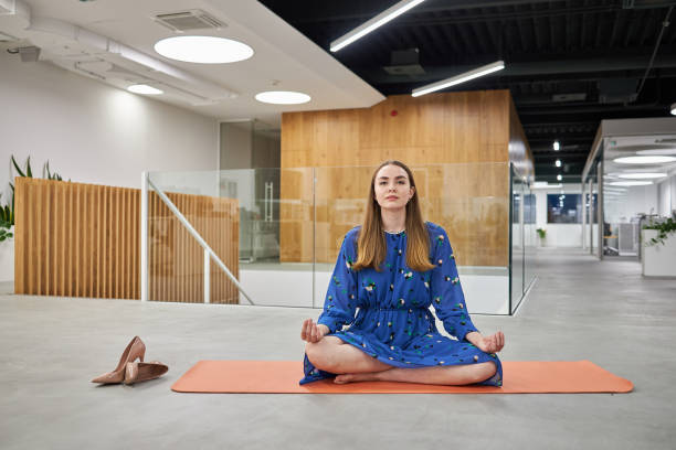 geschäftsfrau in lotus-position, die yoga übt, während sie eine pause von der arbeit einnimmt - zen like meditating yoga business stock-fotos und bilder