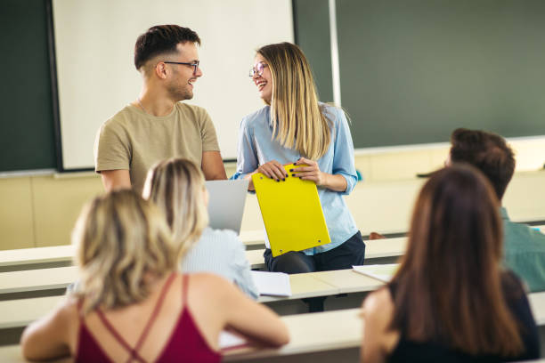 istock Smiled female and male student at the class talking 1272217313
