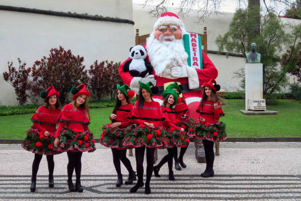Christmas girls posing with Santa Claus Funchal, Madeira, Portugal - 12/13/2015: group of Christmas girls models posing with huge Santa Claus funchal christmas stock pictures, royalty-free photos & images