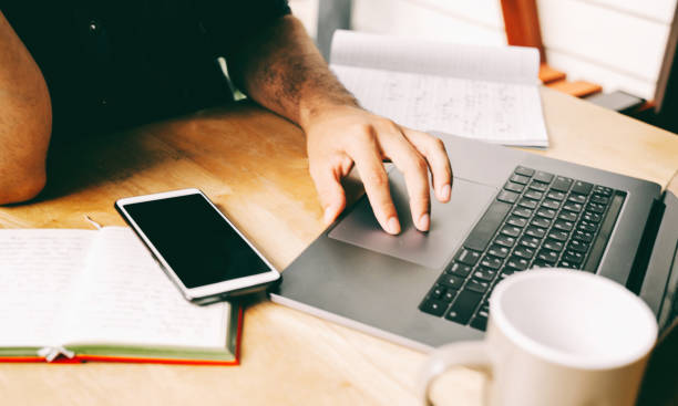 istock A man is typing on a laptop, workplace, hands close-up. Coffee and notebooks on the table 1272224899