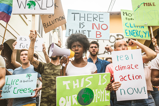 Group of activists is protesting outdoors - Crowd demonstrating against global warming and plastic pollution, concepts about green ecology and environmental sustainability