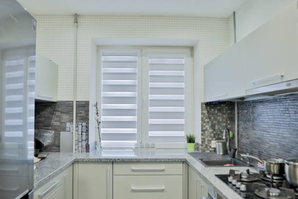istock Modern gray kitchen features gray flat front cabinets paired with gray countertops and a glossy gray linear tile backsplash. 1272226352