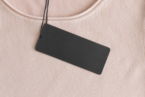 istock Black clothing tag mockup on a soft pink sweater. 1272228526