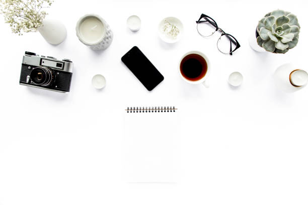 istock Office table desk. retro camera, glasses, phone, coffee on white background. Flat composition, magazines. Home office workspace. flat lay, top view 1272229320