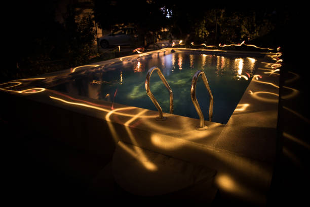 istock Pool and waterfall at night - vacation background. Colorful light decoration. Freezelight 1272231763