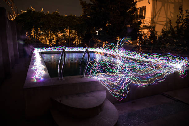 istock Pool and waterfall at night - vacation background. Colorful light decoration. Freezelight 1272231764