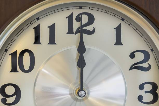 istock Close up macro view of brown clock with light clock face showing  twelve  o'clock. Time concept. Postcard. Beautiful christmas backgrounds. 1272234245