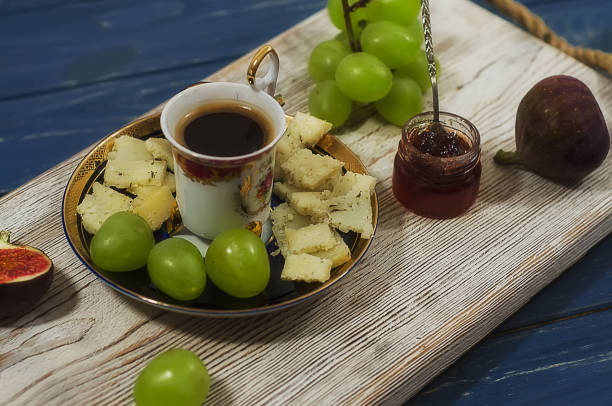 istock Aged cheese with coffee, figs, jam, grapes on wooden background 1272238623