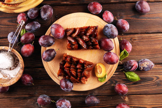 istock Rustic plum cake on wooden background with plums around. 1272240340