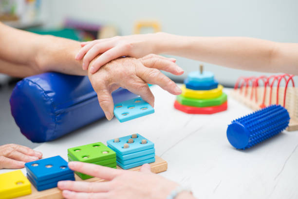 istock Old woman on physical therapy after suffering from stroke 1272243440