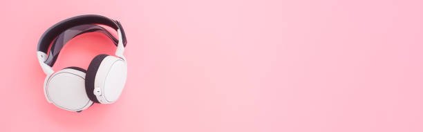istock White music headphones on pink background. web banner size. 1272246652