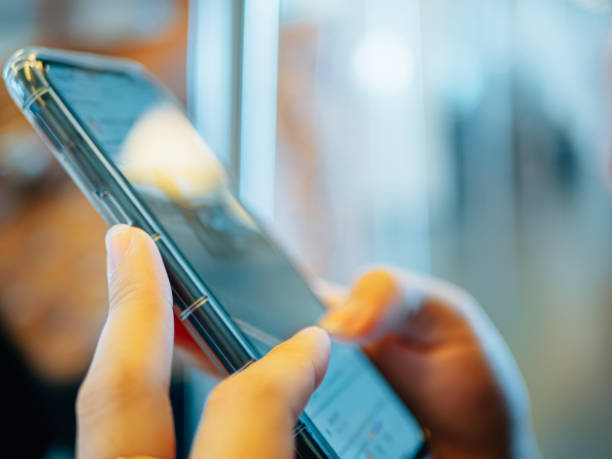 istock close-up technology of hands using smart phone while sit on the electric train 1272246854