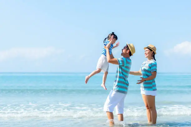 Happy family summer sea  beach vacation. Asia young people father mother and daughter lifestyle travel enjoy fun and relax in holiday. Travel and Family Concept