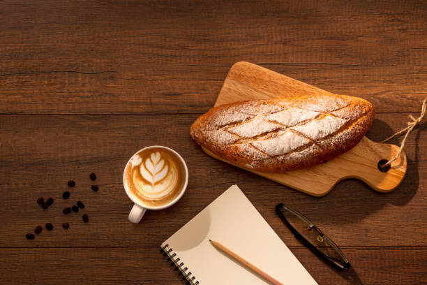 istock Cup of hot coffee with bread on wood background 1272251610