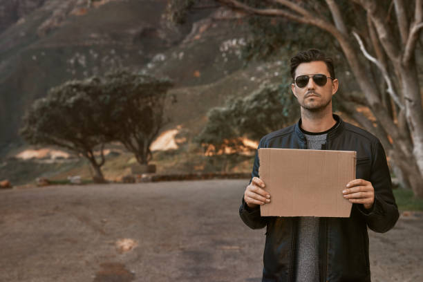 istock Handsome man holding a blank cardboard 1272253037