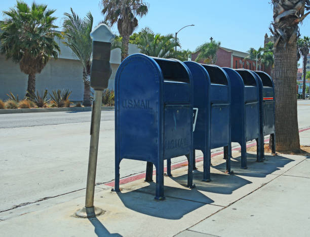 Four Mailboxes on the Sidewalk Four mailboxes next to each other on the sidewalk in Santa Monica, CA. blue mailbox stock pictures, royalty-free photos & images