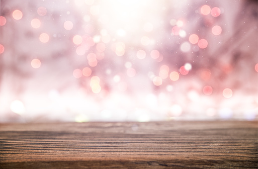 Empty rustic wooden table with blurred Christmas lights in the background