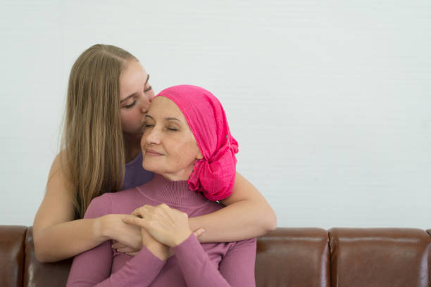 Young adult female cancer patient spending time with her daughter at home. Take medicine family support concept. Young adult female cancer patient spending time with her daughter at home. Take medicine family support concept. lymphoma photos stock pictures, royalty-free photos & images