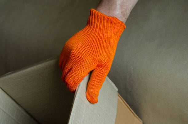 istock A hand in a protective glove is holding an empty cardboard box. 1272256394
