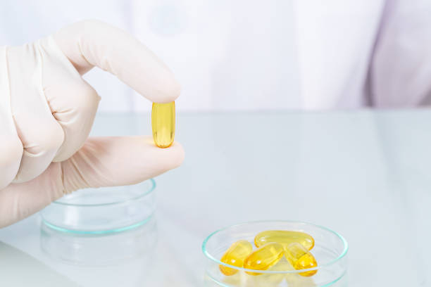 istock Close up Scientist holding Omega 3 capsule in labcoat 1272256496