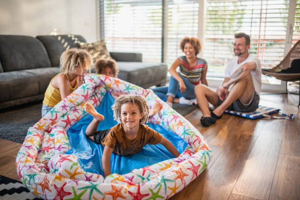 istock Young Boy Climbing Into Inflatable Pool And Having Fun With Family 1272256841