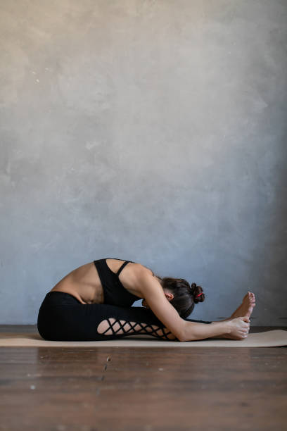 istock Girl bent down to her feet, practice stretch exercise at yoga class. 1272256994
