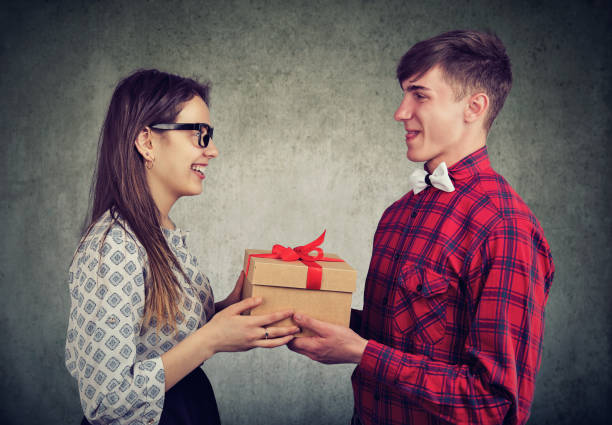 couple exchanging with gift - valentines day love nerd couple imagens e fotografias de stock